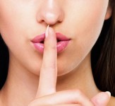 Cropped image of beautiful woman with finger on her lips - copyspace